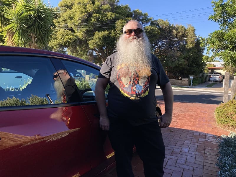 Santa Claus on his day off preparing to drive a Tesla.