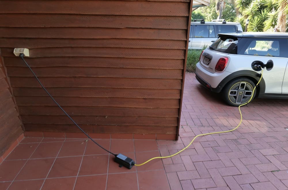 An electric Mini charging from a portable charger