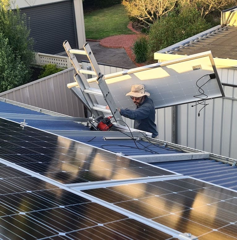 carrying a solar panel up a ladder