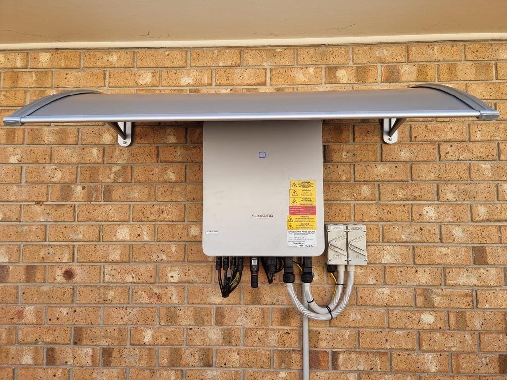 A sungrow solar inverter, installed under a shade